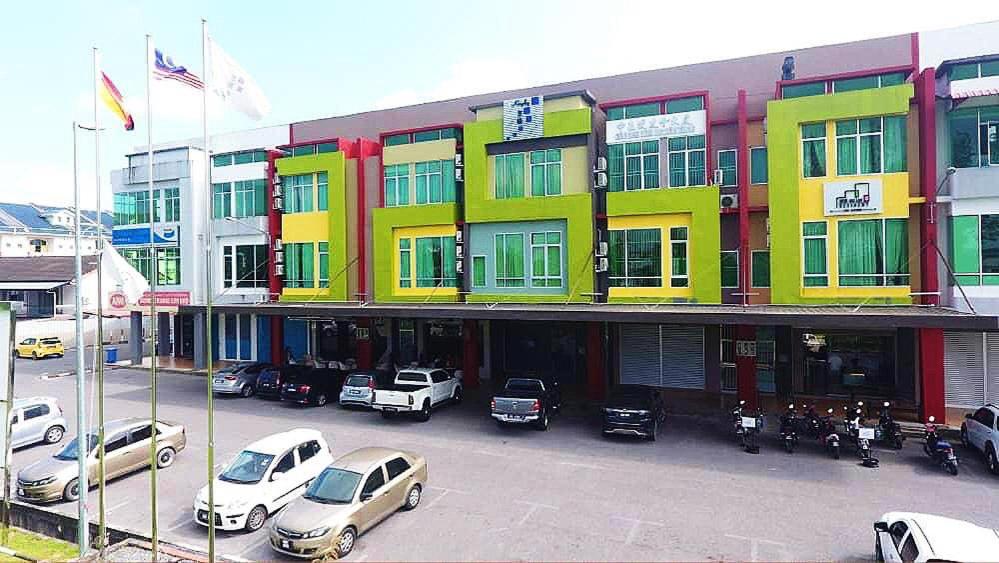 un edificio con coches estacionados en un estacionamiento en Qu Lin Resident, en Sibu