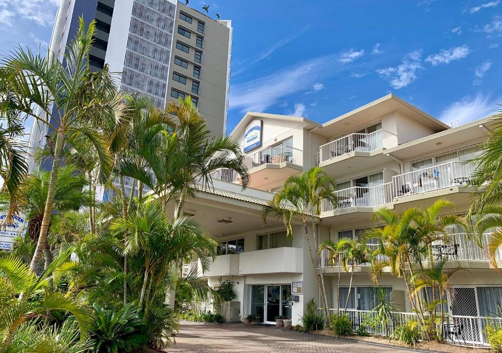 a large building with palm trees in front of it at Outrigger Burleigh in Gold Coast