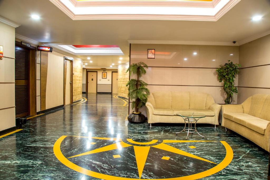 a lobby with couches and a logo on the floor at Hotel Tip Top Plaza in Thane