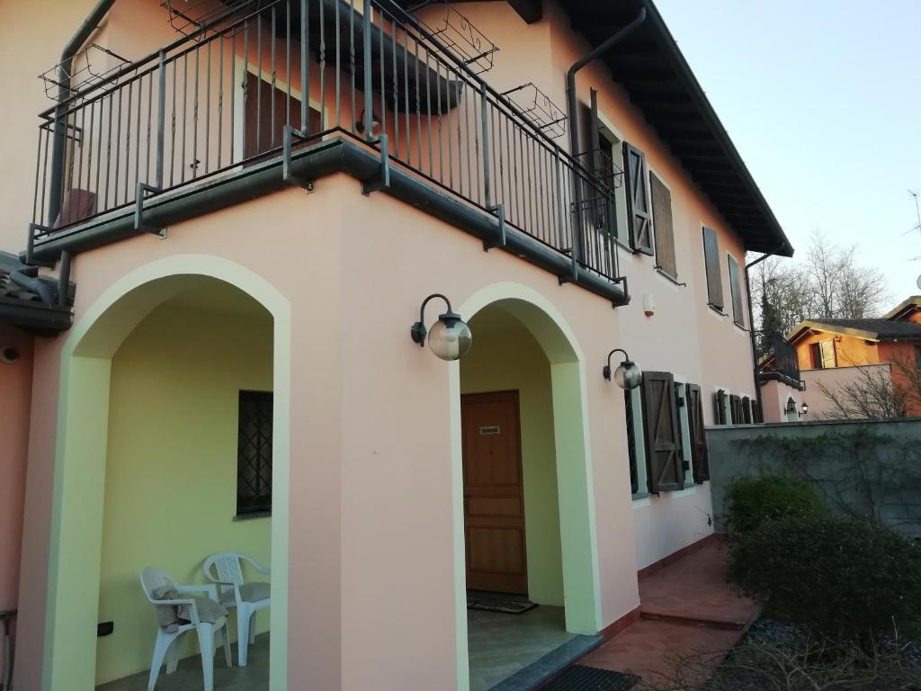 a house with a balcony and a door and a table at B&B La casa dei frutti di bosco in Garlasco