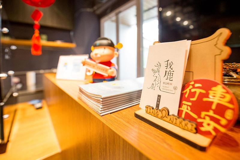 een speelgoedbeeldje op een bureau met een boek bij mydeer backpacker in Tainan