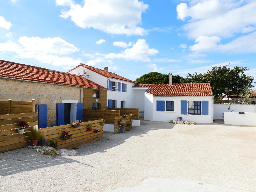 una casa con puertas azules y una valla en Clos des Aigrettes, Gîtes à La Cotinière, en La Cotinière