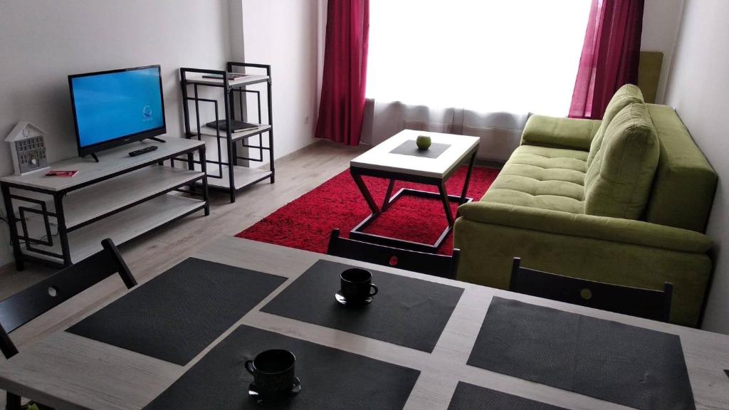 a living room with a couch and a television at Fly Up Home apartment in Boryspilʼ