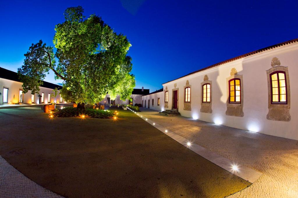 a building with a tree in the middle of a street at Quinta da Lapa in Manique do Intendente