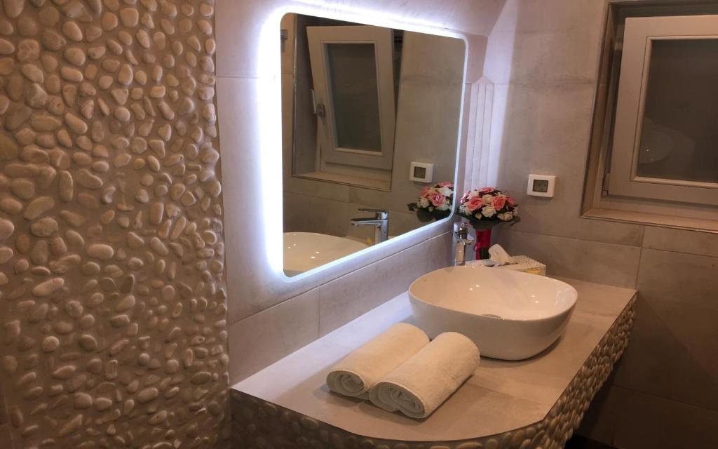 a bathroom with a sink and a mirror at Ariana Eco Suites Adults Only in Fira