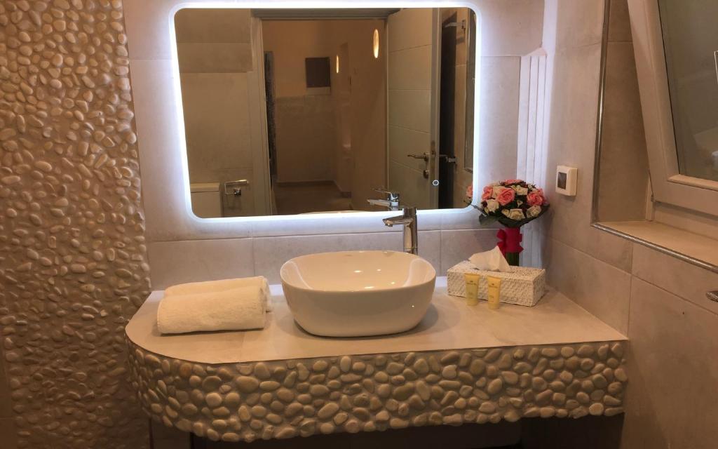 a bathroom with a sink and a mirror at Ariana Eco Suites Adults Only in Fira