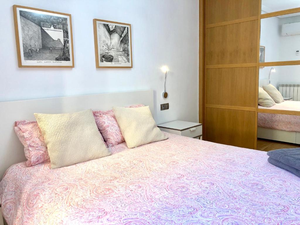 um quarto com uma cama com um cobertor rosa em Gros Beach Apartment em San Sebastián