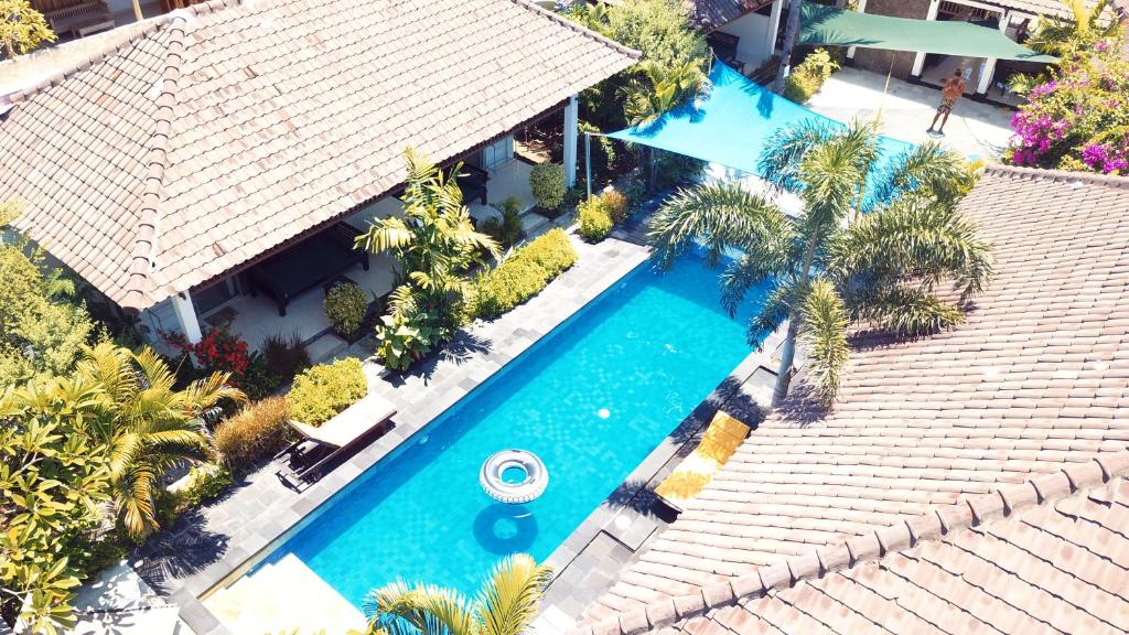 an overhead view of a swimming pool with palm trees at Gili Palms Resort in Gili Trawangan