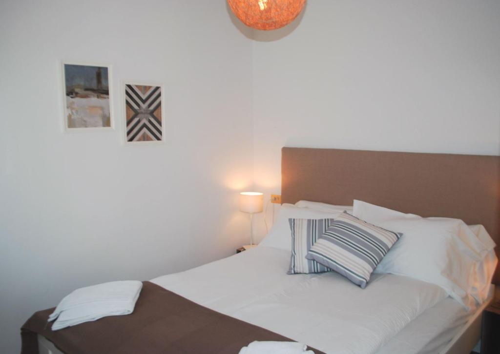 een slaapkamer met een wit bed met 2 kussens bij Appartamento Bijoux - Rebomaholidays in Tignale