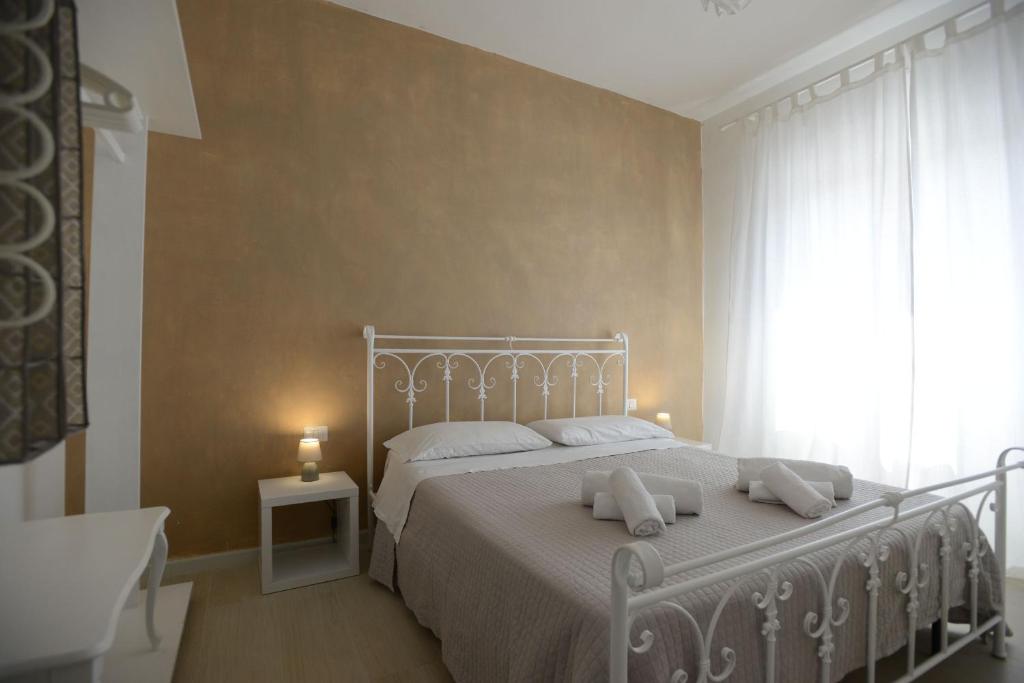 a bedroom with a white bed and a window at B&B Alghero 82 in Alghero