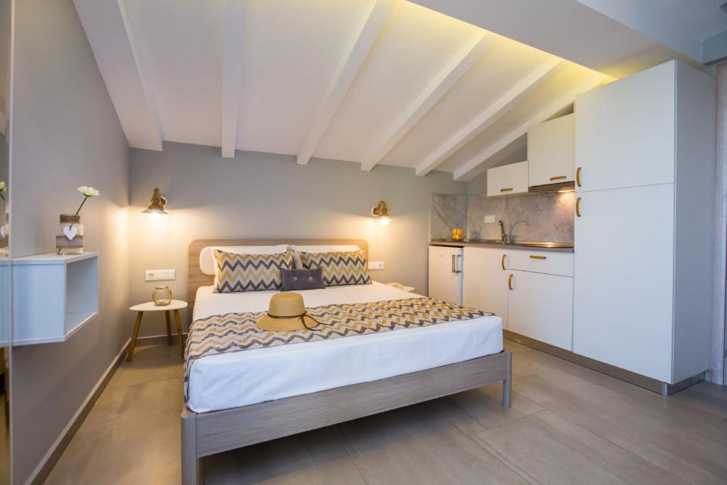 a bedroom with a bed with a hat on it at GiRene Apartments in Limenaria