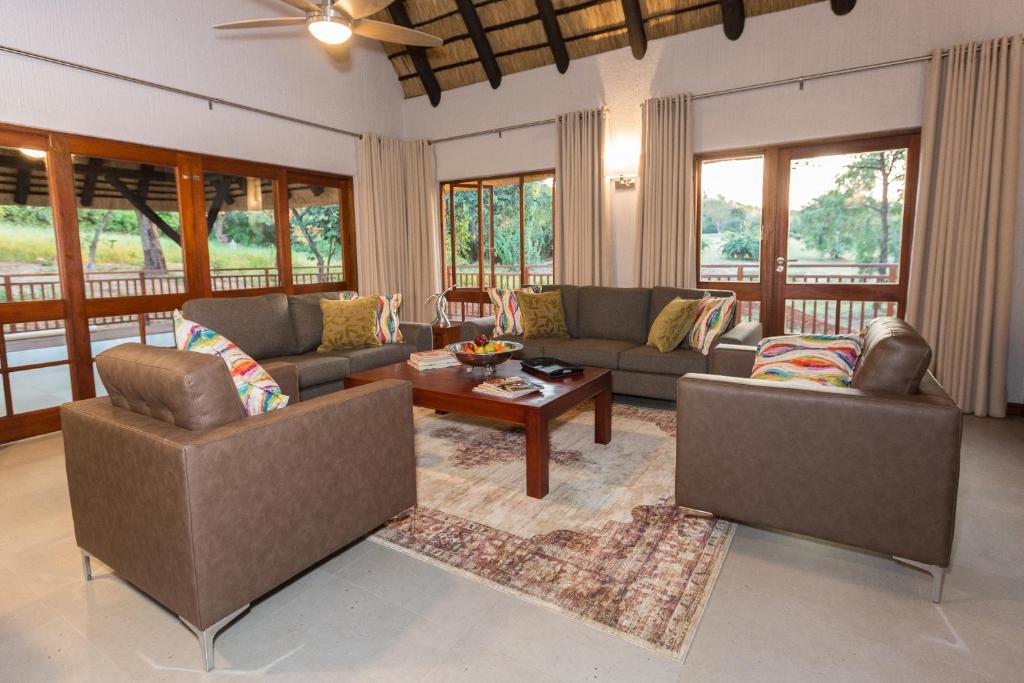 a living room with two couches and a table at Kruger Park Lodge Unit No 611 with private splash Pool in Hazyview