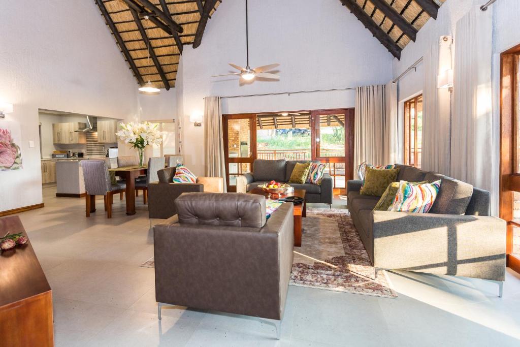 a living room with couches and a dining room at Kruger Park Lodge Unit No. 611 in Hazyview