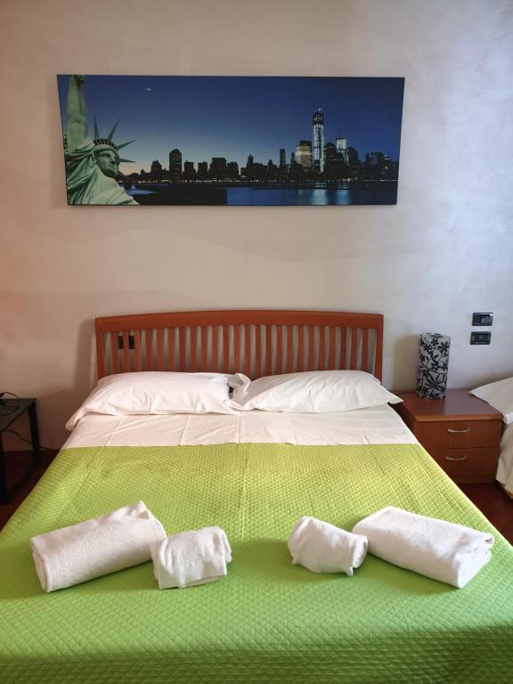 a bed with two towels on top of it at Caravaggio Apartments in Bergamo
