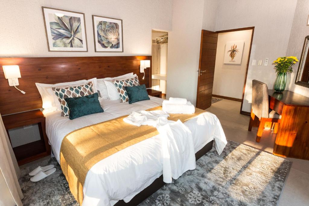 a hotel room with a large bed and a desk at Kruger Park Lodge Unit No 612 with private splash Pool in Hazyview