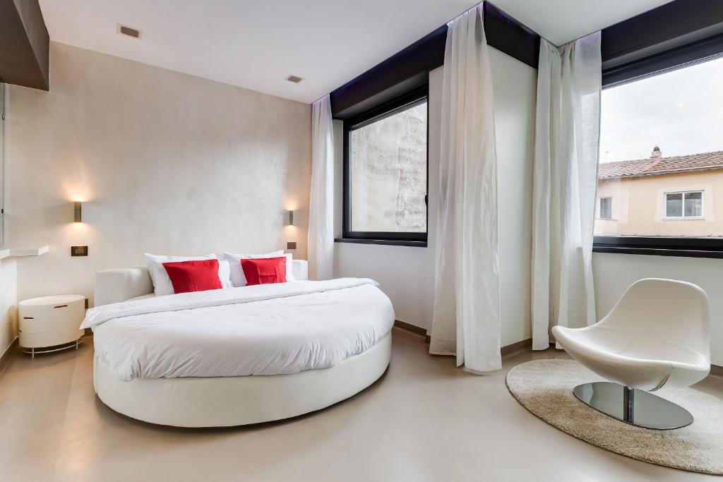 una camera da letto con un grande letto bianco con cuscini rossi di EMERALD Luxury Suite Apartment a Roma