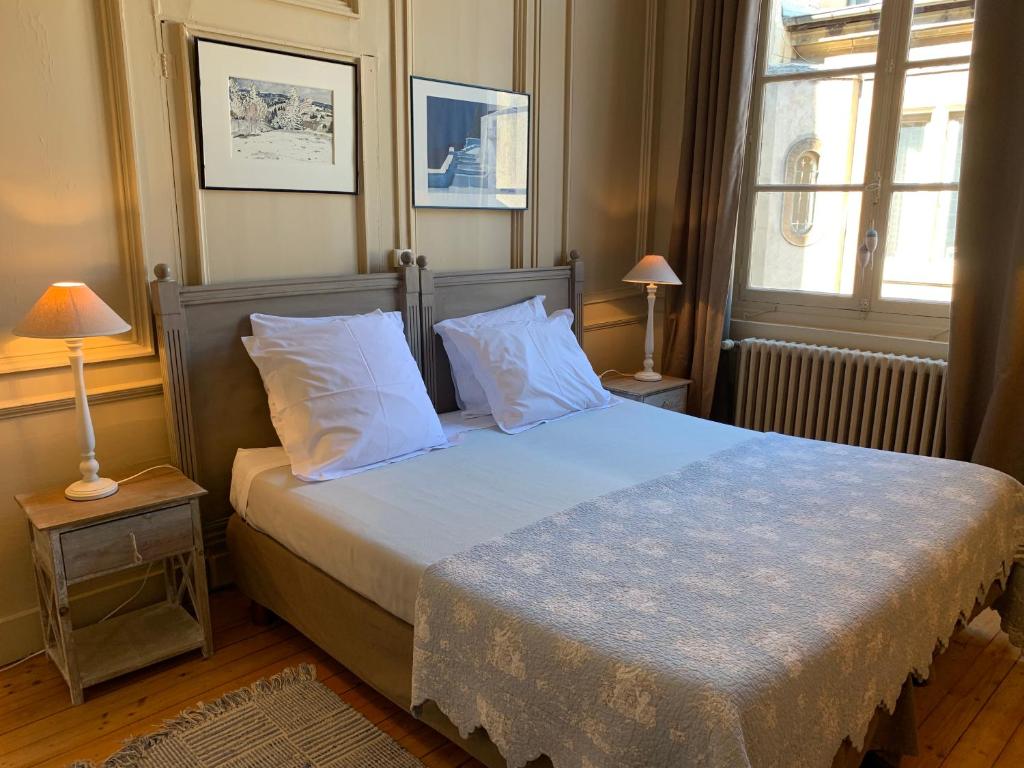 a bedroom with a bed with white pillows and a window at L'Annexe Apparthôtel du 11 A, 4 étoiles in Besançon