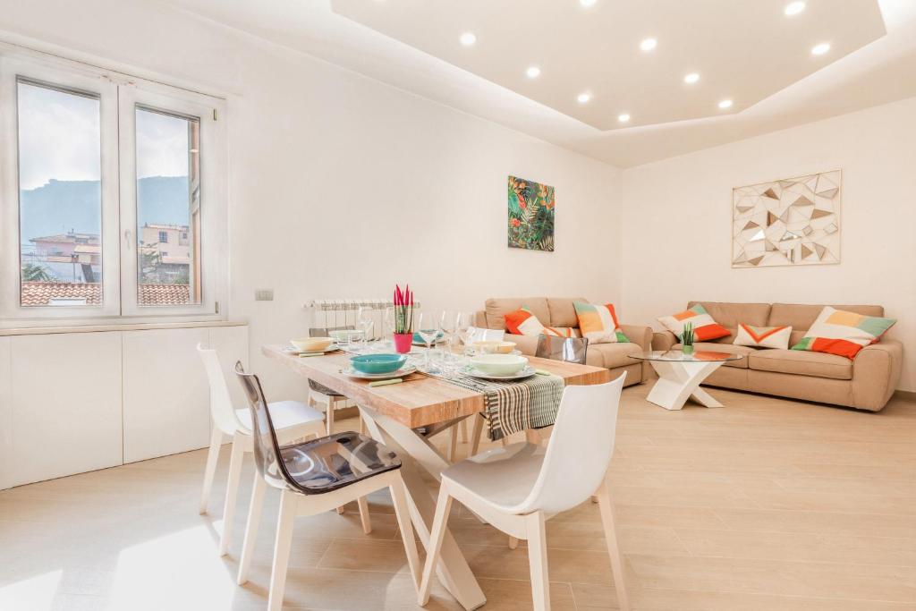 a dining room and living room with a table and chairs at Appartamento Sorrento Sunrise in Sorrento