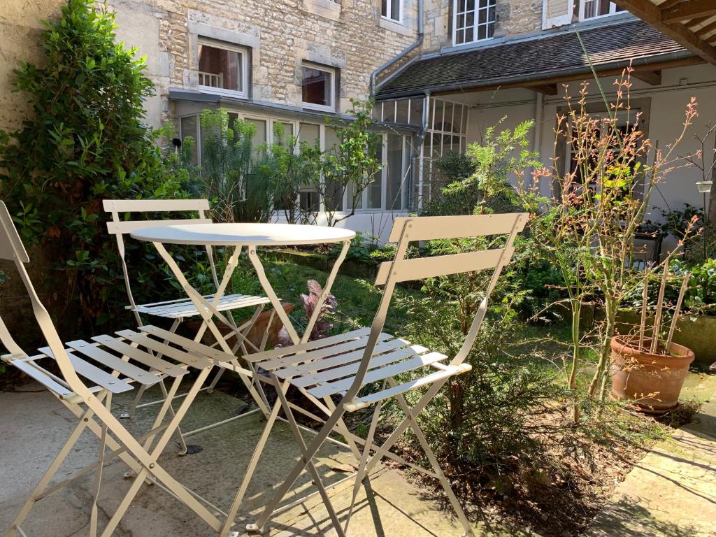 two chairs and a table and a table and chairs at L'Annexe Apparthôtel du 11 D, 4 étoiles in Besançon