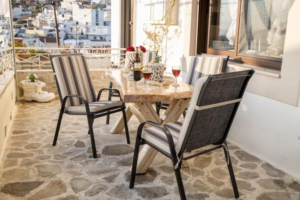 - une table et des chaises en bois dans une chambre avec fenêtre dans l'établissement Kleopatra Apartment, à Kamilárion