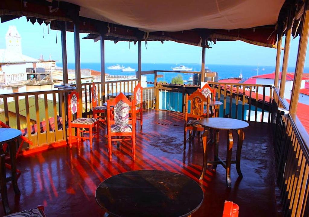 a restaurant with tables and chairs on a balcony at Bottoms Up in Zanzibar City