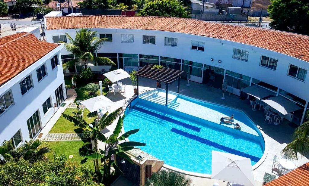 an aerial view of a building with a swimming pool at Mandakaru Residence Flats in Porto De Galinhas