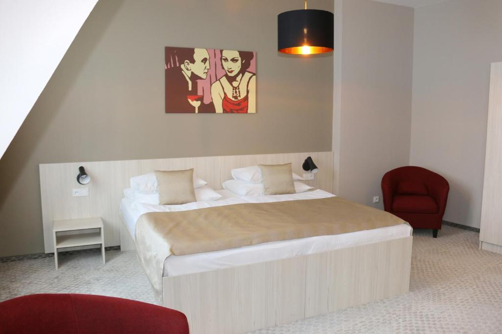 1 dormitorio con 1 cama grande y 1 silla roja en 1.Republic Hotel en Praga