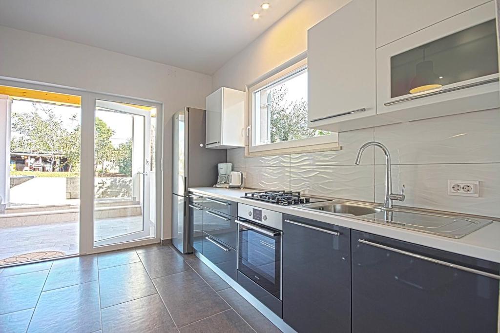 eine Küche mit Spüle und Herd in der Unterkunft *Amazing modern apartment with 2 bedrooms* in Vodnjan