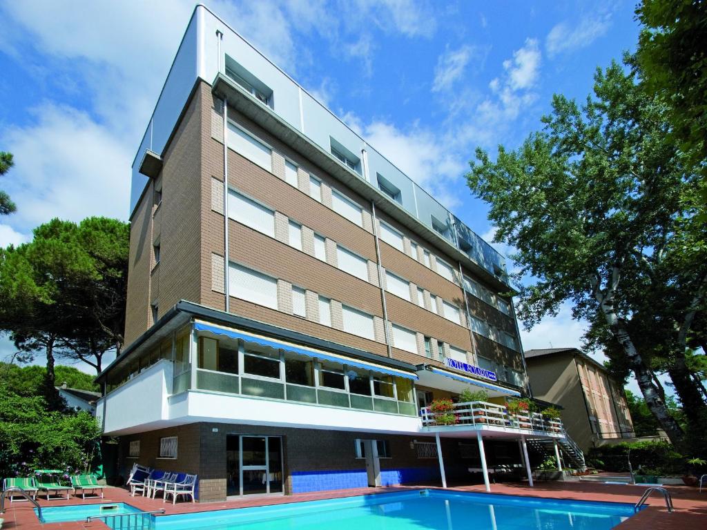 a building with a swimming pool in front of it at Hotel Solaria in Marina Romea