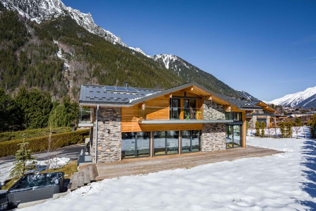 a house in the mountains with snow on the ground at Chalet Montana- Chamonix All Year in Chamonix-Mont-Blanc
