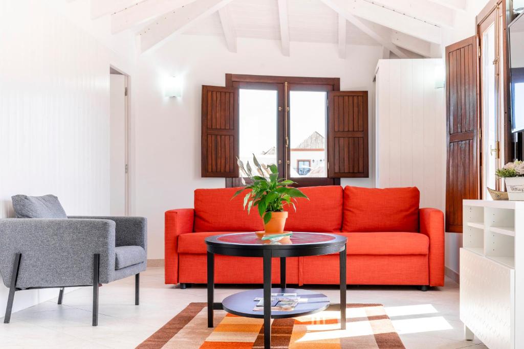 a living room with a red couch and a table at Loft 1º de Maio in Tavira