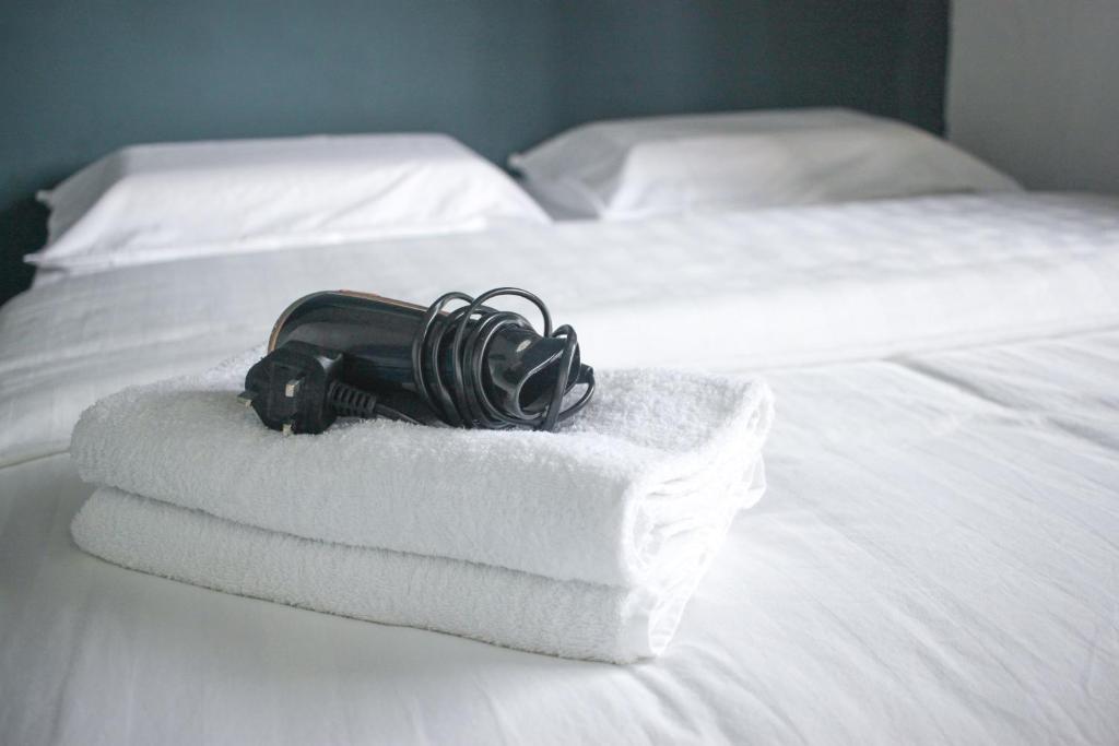 a pile of towels and a hair dryer on a bed at TEMPO in Semporna