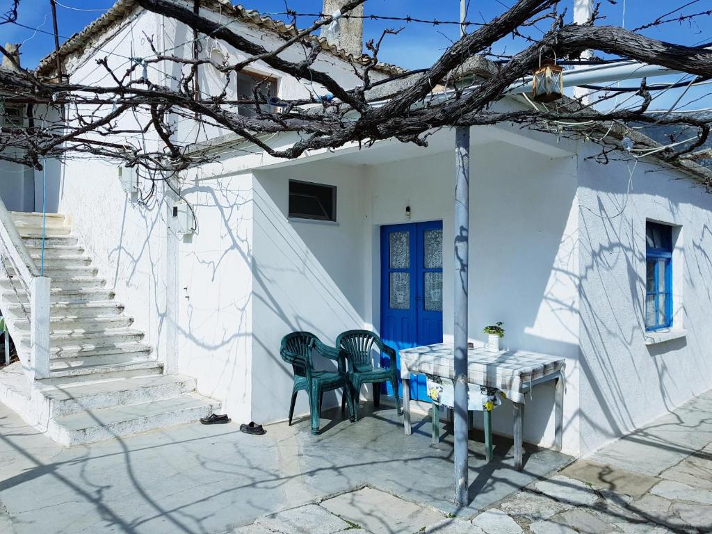 einen Tisch und Stühle vor einem weißen Haus in der Unterkunft The Grandfather's Room in Himarë