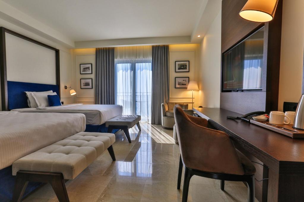 a hotel room with a bed and a desk at Hotel California by Aycon in Sveti Stefan