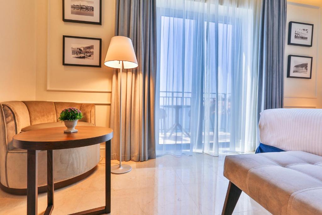 a living room with a couch and a table at Hotel California by Aycon in Sveti Stefan
