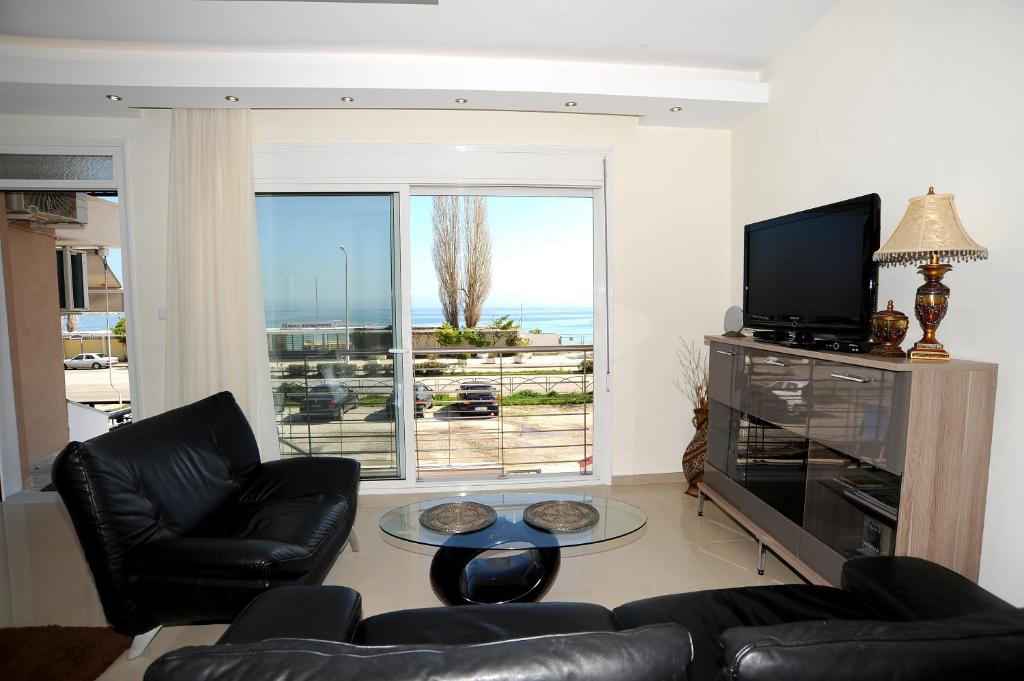 a living room with a couch and a television at Thalia Premium Apartment in Kavála