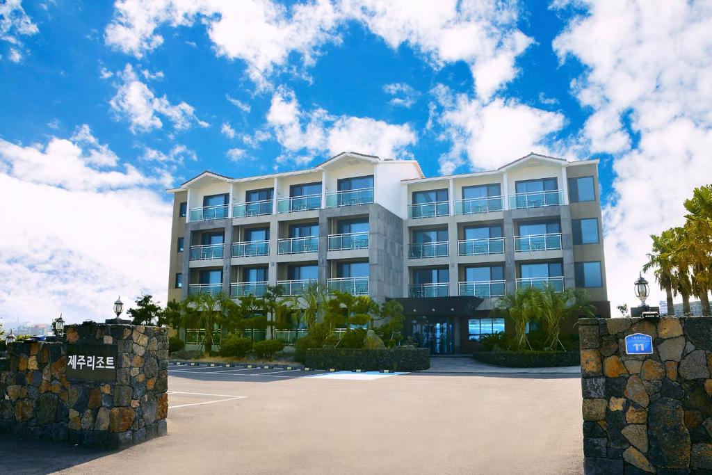 濟州的住宿－濟州島度假酒店，一座白色的大建筑,前面有棕榈树