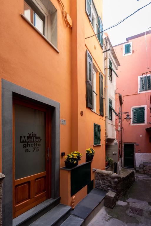 an orange building with a door and flowers on a street at Meb in Riomaggiore