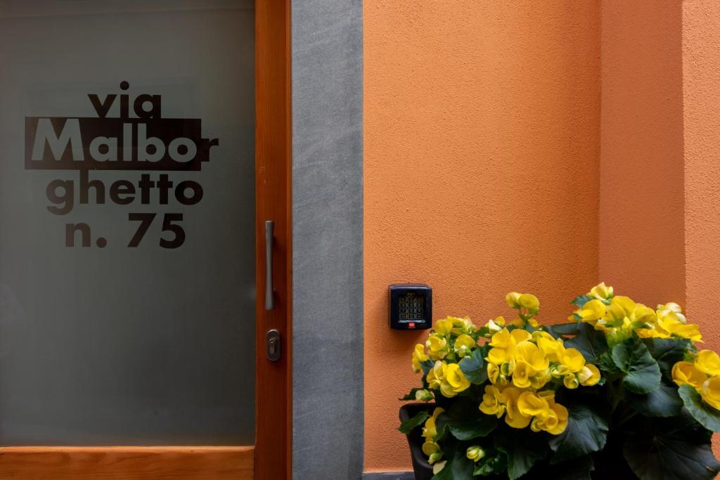 a vase of yellow flowers next to a door at Meb in Riomaggiore
