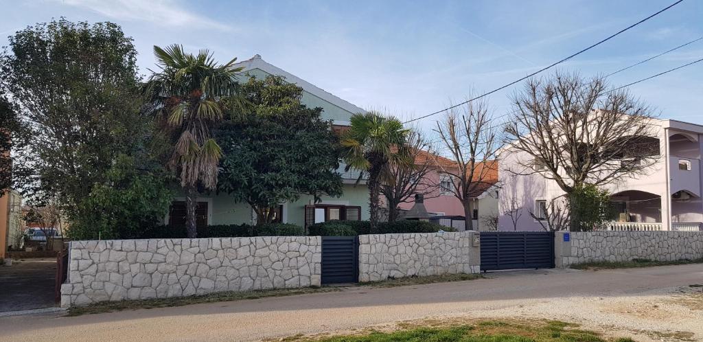 una casa con una pared de retención y una valla en Apartment Jadranka, en Zadar