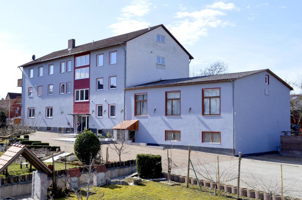 ein großes weißes Gebäude neben einer Straße in der Unterkunft Hohe Tanne in Schnelldorf