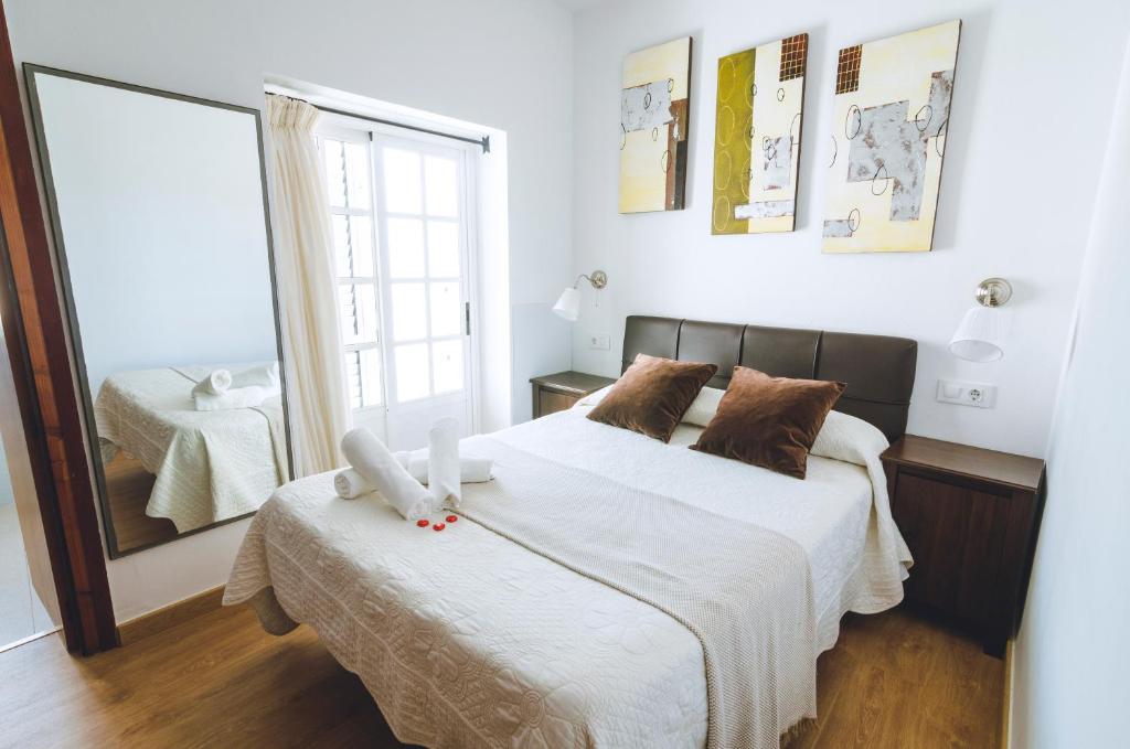 a bedroom with two beds and a mirror at Hospedaje Villanueva in Tarifa