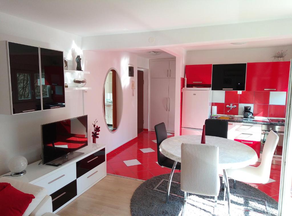 a room with a table and a kitchen with red at Studio apt. Downtown in Split