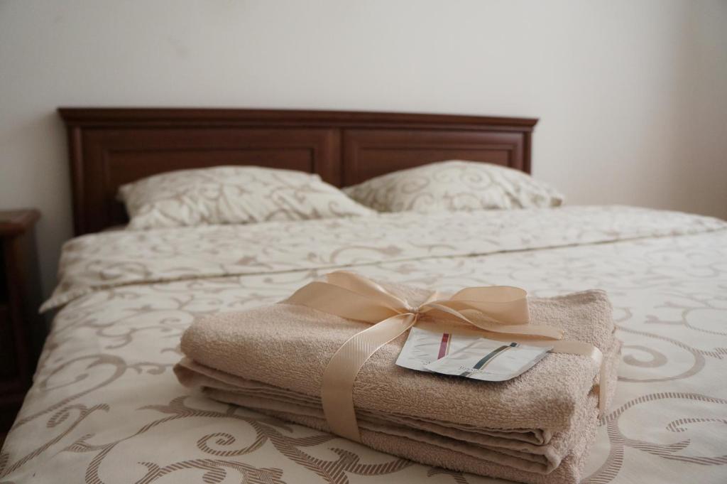 a bed with a pile of towels with a bow on it at Peka Apartment in Lviv