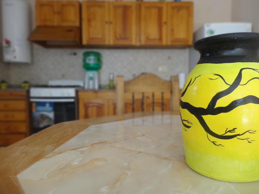 a yellow vase sitting on a table in a kitchen at Alojamiento Tierras del Sol - Departamento 02 in Las Heras