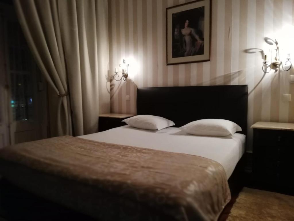 1 dormitorio con 1 cama con 2 almohadas blancas en Brasilia, en Lisboa