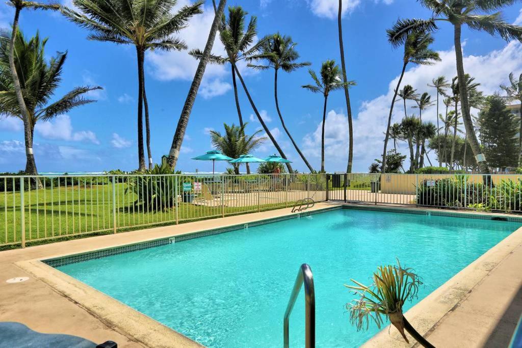 a swimming pool with palm trees in the background at South Kihei Luxury Condos in Kihei