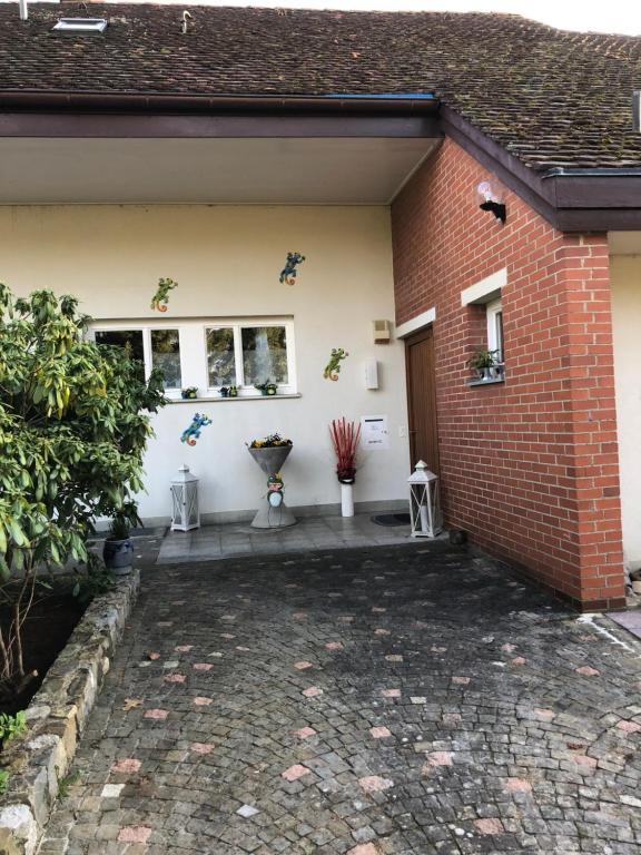 a brick house with a patio in front of it at Casa Wellbella in Unterkulm