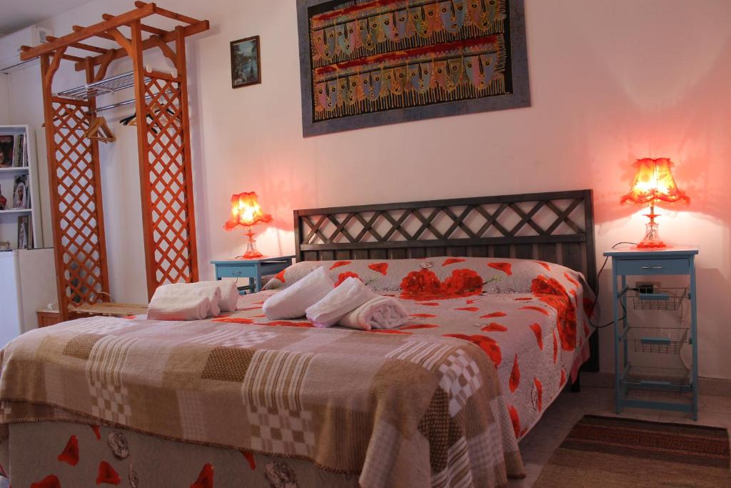 una camera con un letto con due comodini e due lampade di B&B Su Nuraghe a SantʼAntìoco
