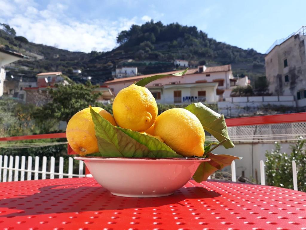 a bowl of lemons sitting on a table at Osolemiohouse in Minori
